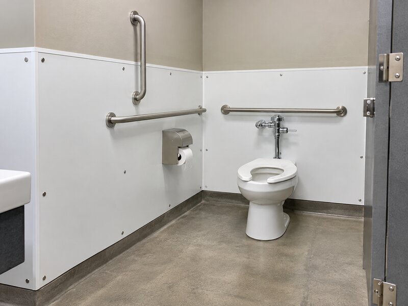 White bathroom wall panels installed in an ADA-accessible restroom stall with grab bars
