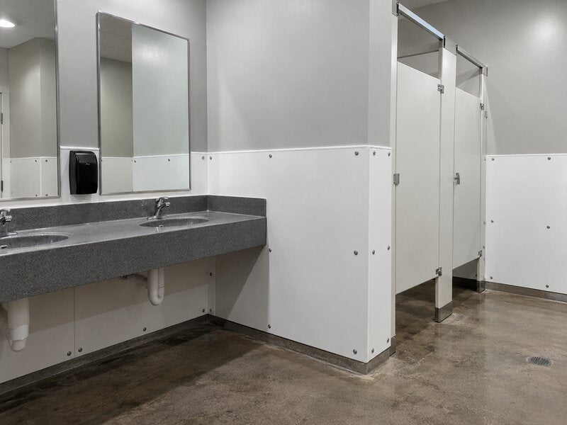 Bathroom wall panels installed along a sink counter and restroom stall doors
