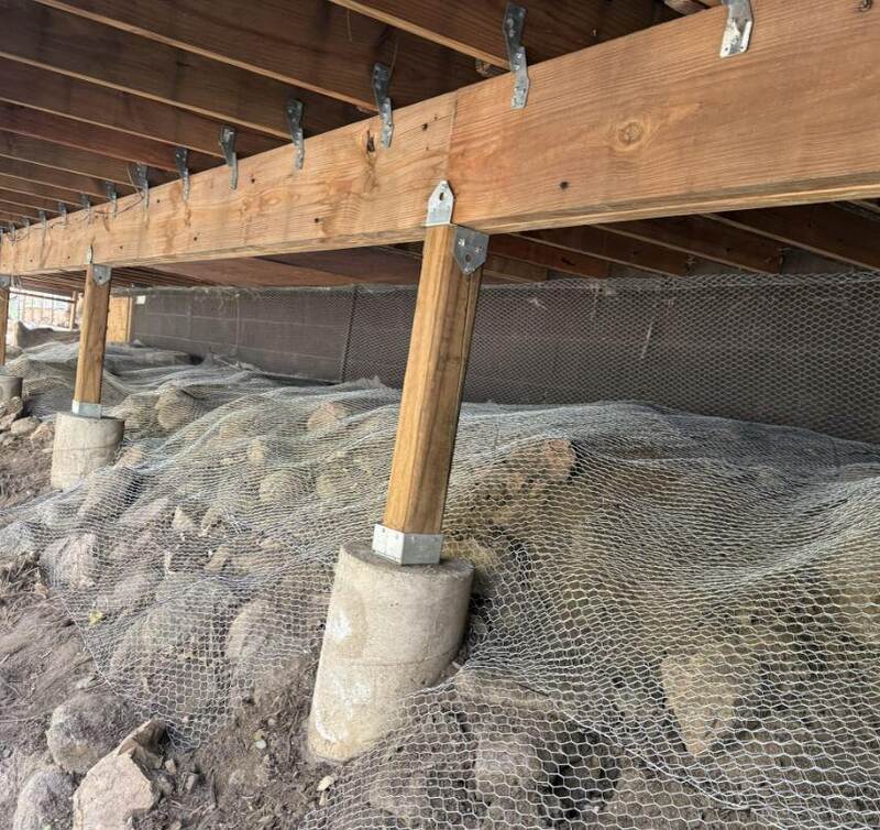 Galvanized wire mesh burrowing rodent fence in a crawl space
