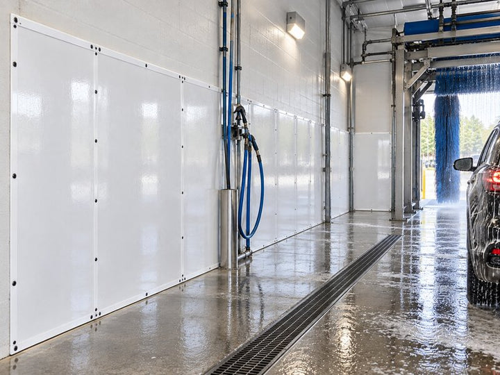 SUV being washed in an automated brush tunnel lined with car wash wall panels
