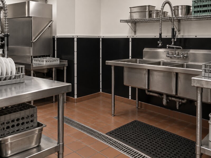 Black FRP wall panels installed in a commercial dishwashing station corner
