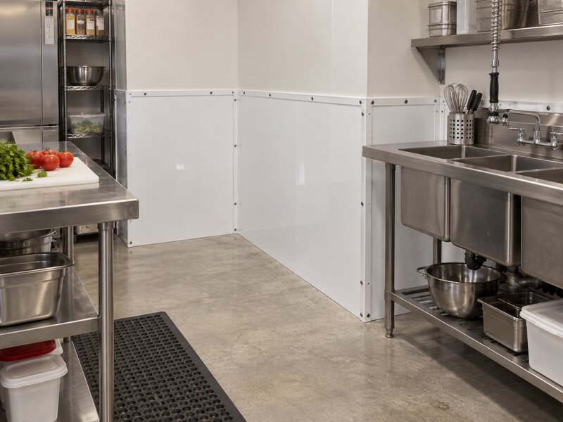White FRP wall panels installed in a prep area corner near wire shelving
