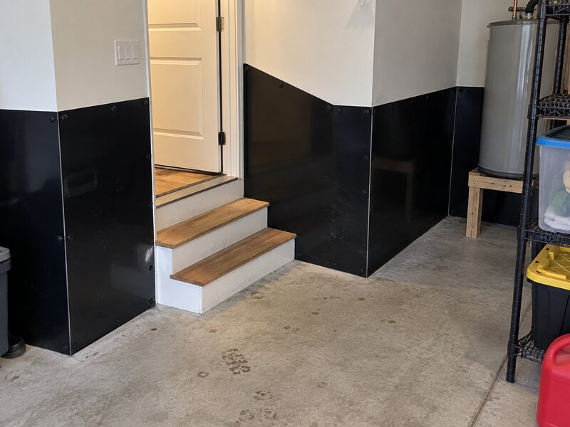 Garage stairwell entry with black HDPE wall liner installed around the base of the walls
