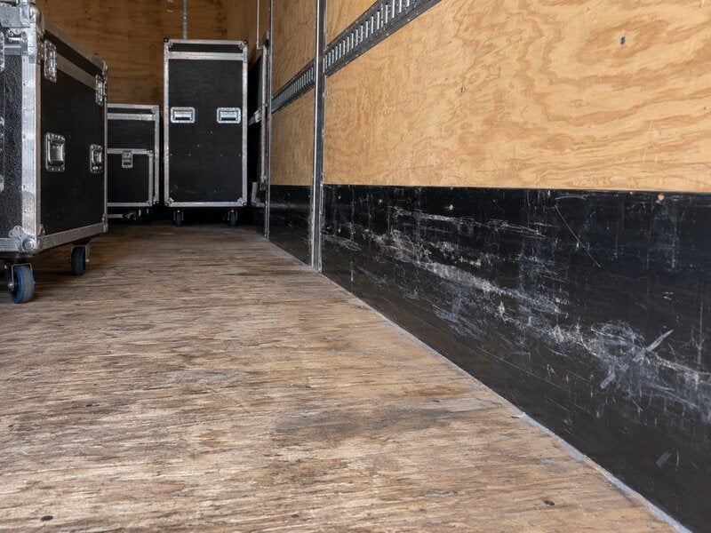 Road cases stored in a cargo trailer with HDPE wall liner protecting the lower walls
