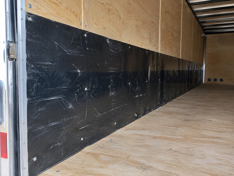 Close-up of HDPE wall liner panel installed near a cargo trailer side door
