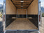 Enclosed trailer interior with HDPE wall liner on both walls, mountain view through open door
