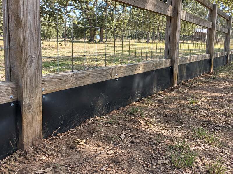 HDPE fence barrier installed along a farm wood rail and wire fence bordering a pasture

