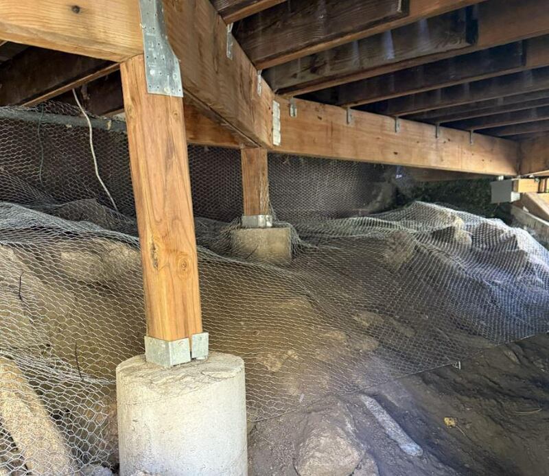 Wire mesh rodent barrier installed under a structure around a pier
