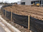 Silt fence installed along a curb at a commercial building construction site
