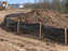 Silt fence installed around a large dirt stockpile at a subdivision construction site
