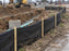 Silt fence installed beside a utility trench with pipe at a construction site
