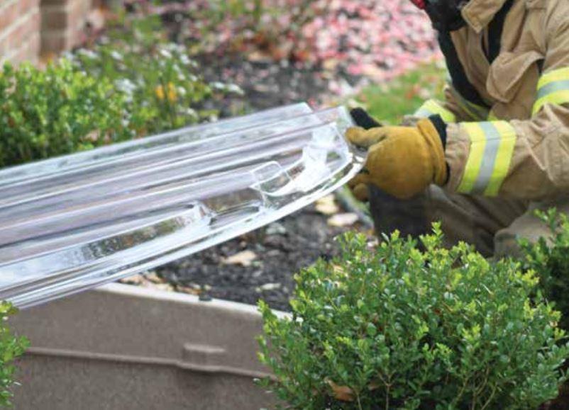 Firefighter lifting up the egress window well cover 